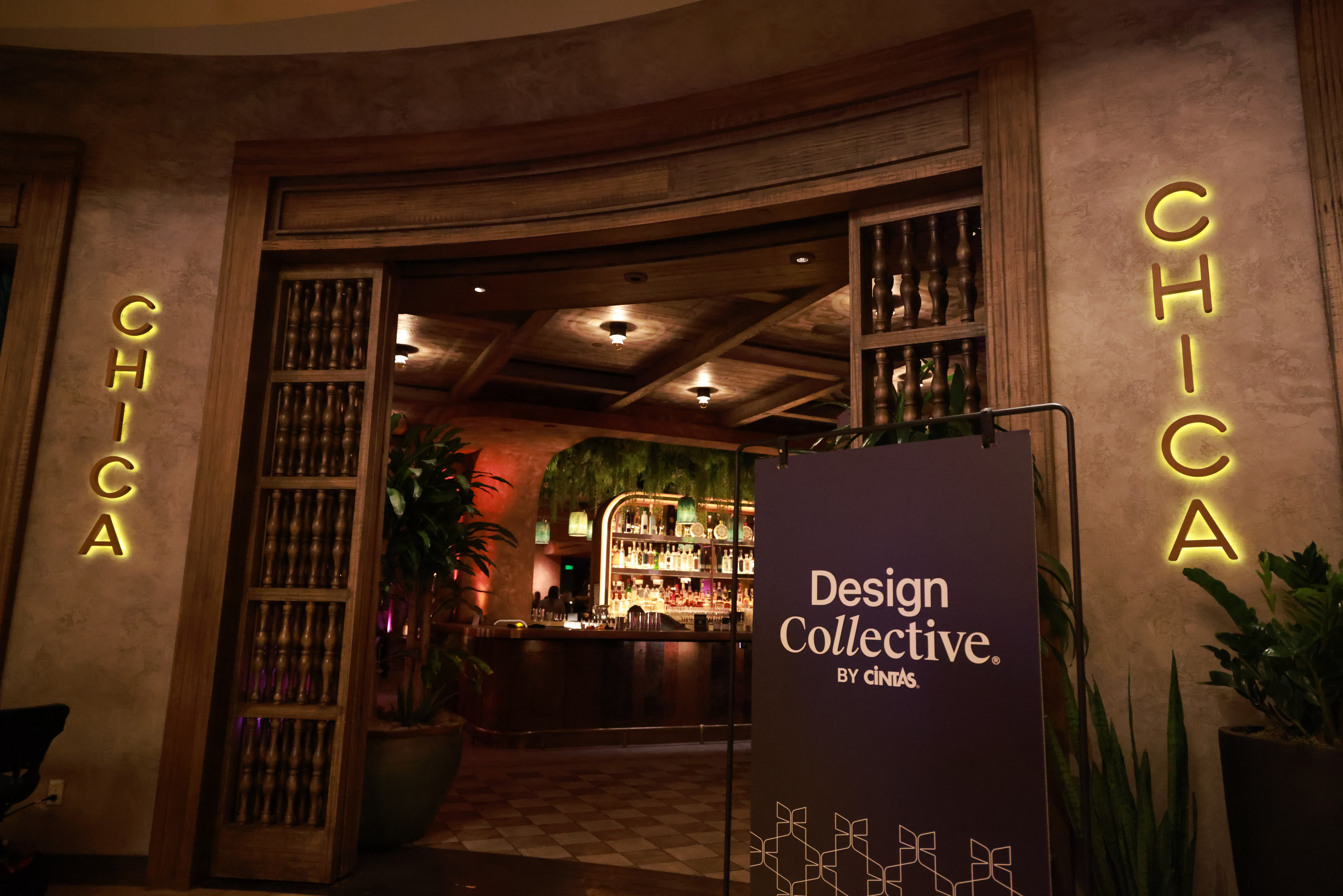 Entrance to CHICA restaurant, with its name illuminated on the wall and a 